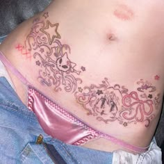 a woman's stomach with tattoos on it and stars around the bottom part of her belly