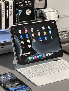 an open laptop computer sitting on top of a desk next to a phone and other electronics