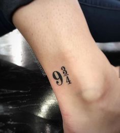 a woman's foot with the number nine tattoo on her left ankle and an inscription in black ink