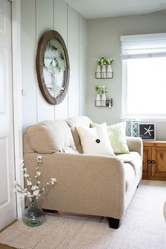 a living room filled with furniture and a clock on the wall above it's headboard