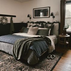 a bedroom with a bed, rug and two lamps on the side of the room