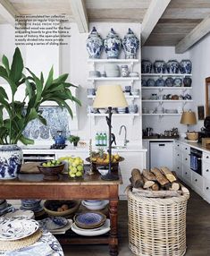 the kitchen is decorated with blue and white dishes, plates, bowls, vases and baskets