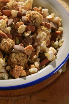 a bowl filled with popcorn and nuts on top of a table