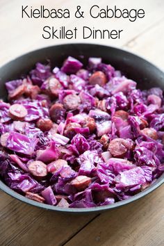 kielbasa and cabbage skillet dinner in a pan on top of a wooden table