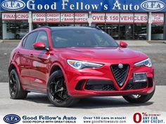 a red alfa coupe parked in front of a dealership with the words good fellow's auto