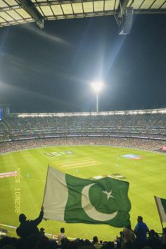 a large pakistan flag is being held up in a stadium