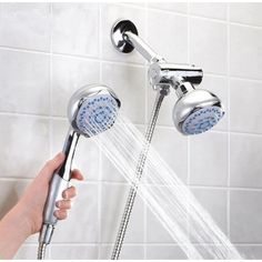 a person is holding the shower head in their hand and it's spraying water