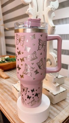 a pink coffee cup sitting on top of a wooden table