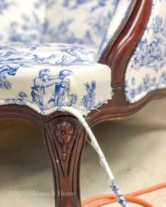 an upholstered chair with blue and white fabric on the armrests is being worked on