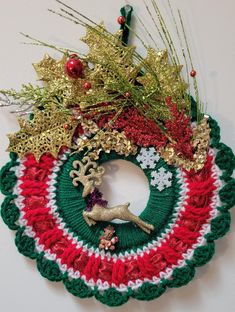 a crocheted christmas wreath hanging on the wall