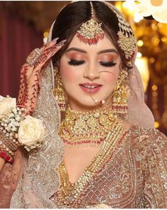 a woman wearing a bridal outfit and jewelry