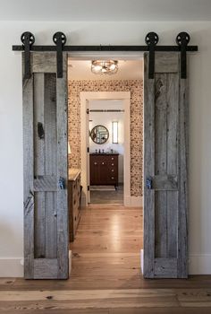 an open door leading to a bathroom with wood floors