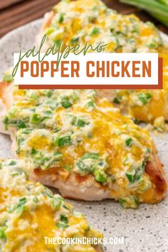 two pieces of chicken covered in cheese and green onions on a plate with text overlay