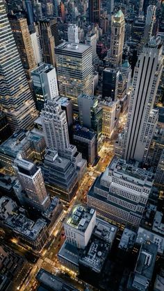 an aerial view of skyscrapers in new york city at night, with lights on