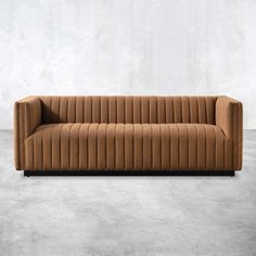 a brown couch sitting on top of a cement floor