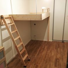 a loft bed with a wooden ladder in the middle of it and a mirror on the wall