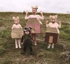 three girls and one boy are dressed up as mouse ears, standing in the grass