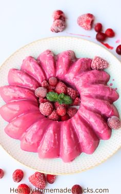 raspberry bundt cake on a white plate surrounded by cranberries