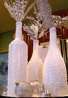 three white vases with silver flowers in them sitting on a counter top next to each other