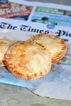 three small pastries sitting on top of a newspaper