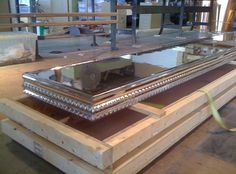 a large metal object sitting on top of wooden pallets in a room filled with boxes