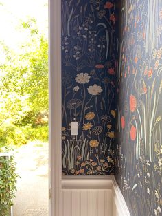 an open door leading to a hallway with floral wallpaper