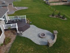 an aerial view of a patio and fire pit in the middle of a lawn area