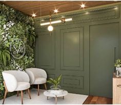 a living room with green walls and plants on the wall