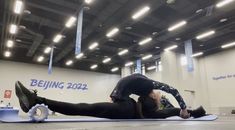 a woman is doing an exercise on a mat in the middle of a large room