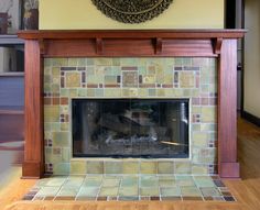 a fireplace with a clock above it in a room that has wood floors and yellow walls