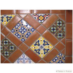 a tile wall with different colors and designs on the tiles, including oranges, yellows and blue