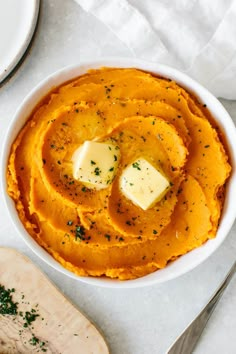 a bowl filled with mashed potatoes topped with butter