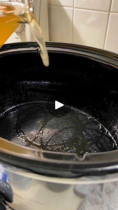 a pot filled with liquid sitting on top of a stove next to a white tile wall