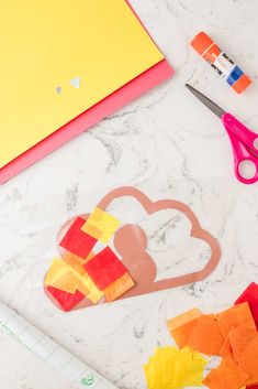 cut out paper hearts sitting on top of a table next to scissors and other crafting supplies