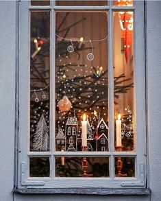 a window decorated with christmas decorations and lit candles