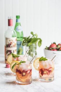 two glasses filled with drinks sitting on top of a table