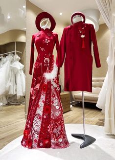 two mannequins dressed in red and white clothing on display at a bridal shop