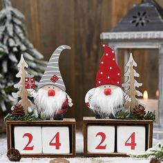 two gnomes sitting on top of wooden blocks with numbers