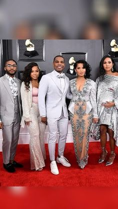 several people standing on a red carpet at an event