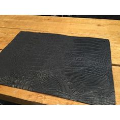 a black placemat sitting on top of a wooden table