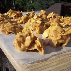 several pieces of food sitting on top of a piece of paper next to a wooden table