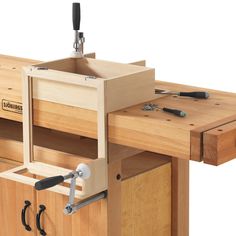 a wooden workbench with two drawers and one drawer open to show the tools inside