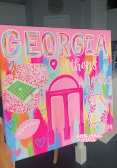 a hand holding up a sign that says georgia