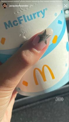 a person's finger with a tiny star on it and mcdonald's logo in the background