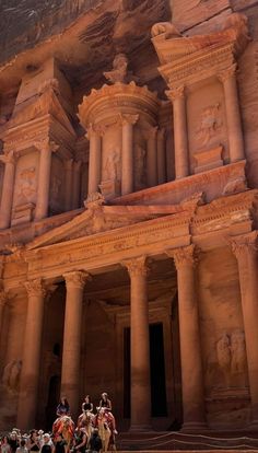 some people riding horses in front of an ancient building