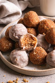 a plate full of doughnuts and nuts with a glass of milk in the background