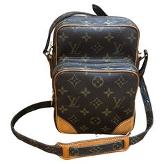 This LOUIS VUITTON Amazon camera crossbody bag is crafted of LV’s coated monogram canvas in brown and vachetta leather featuring brass hardware. This crossbody bag features one bigger and one smaller zippered compartments. Top zipper closure of the bigger compartment opens to a brown leather interior featuring an open pocket. This is a perfect compact camera bag for your cell phone and small accessories. Made in France with date-code TH0029. Measures approximately 6 x 8 x 3.5 inches Strap drop 2 Business Shoulder Bag In Monogram Canvas With Leather Trim, Business Monogram Canvas Crossbody Shoulder Bag, Signature Coated Canvas Rectangular Travel Shoulder Bag, Modern Monogram Canvas Crossbody Shoulder Bag, Travel Shoulder Bag With Removable Pouch And Monogram Canvas, Travel Shoulder Bag With Removable Pouch In Monogram Canvas, Luxury Brown Camera Bag For Travel, Luxury Shoulder Bag In Signature Coated Canvas With Zipper, Luxury Shoulder Bag With Zipper In Coated Canvas