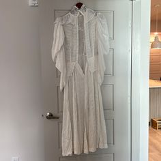 a white dress hanging up on a door