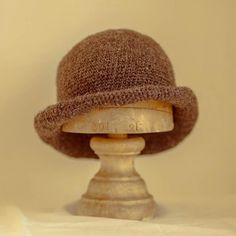 a brown hat sitting on top of a wooden stand