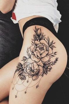 a woman's thigh with flowers and diamonds on the bottom part of her leg